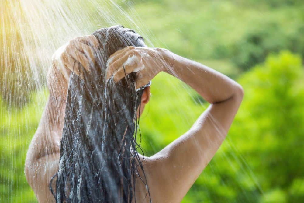 Woman showering and shampooing outdoor